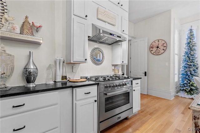 kitchen featuring white cabinets, light wood-type flooring, and stainless steel range