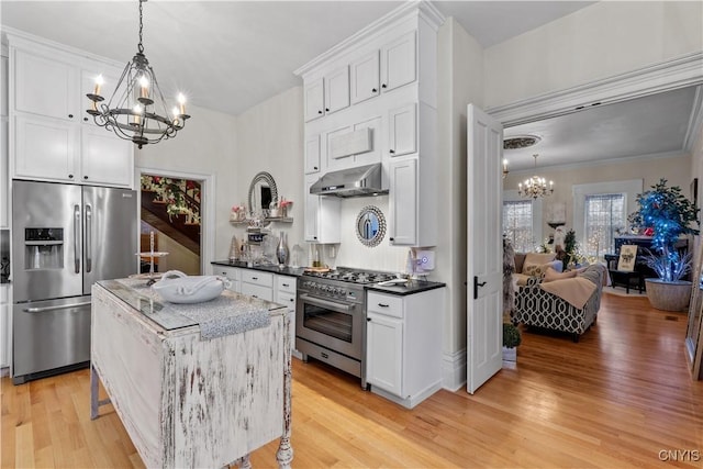 kitchen featuring light wood-type flooring, ornamental molding, stainless steel appliances, decorative light fixtures, and white cabinetry