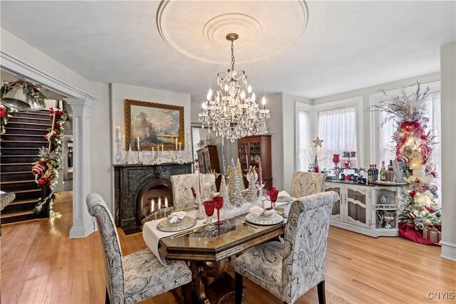 dining space featuring light wood-type flooring and an inviting chandelier