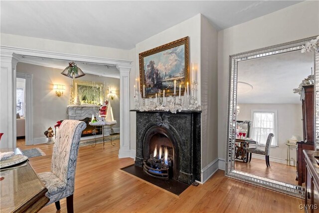 living room with light wood-type flooring and ornate columns