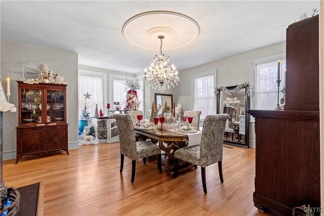 dining room with an inviting chandelier and light hardwood / wood-style flooring