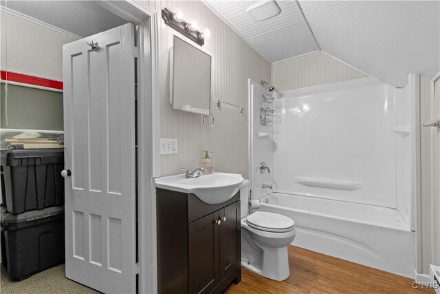 full bathroom with shower / bathing tub combination, vanity, vaulted ceiling, toilet, and wood-type flooring