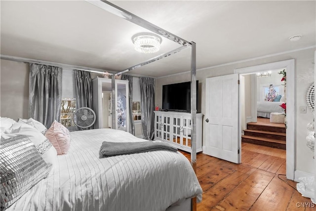 bedroom with ornamental molding and hardwood / wood-style flooring