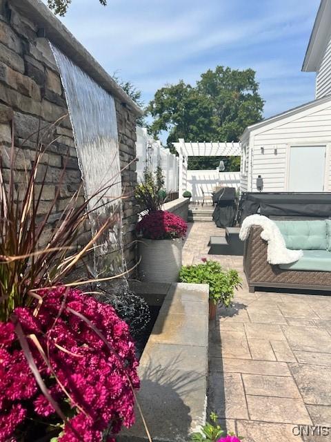 view of patio / terrace featuring a pergola and a hot tub