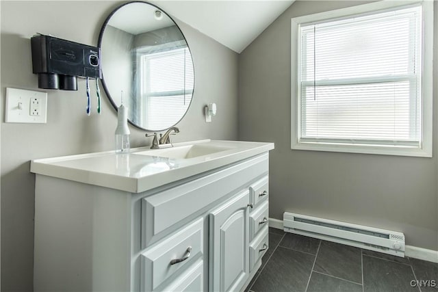 bathroom with vanity, a baseboard heating unit, tile patterned flooring, and vaulted ceiling