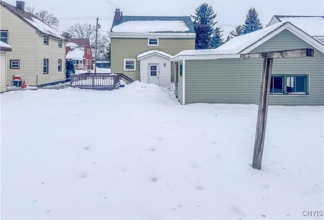 snow covered rear of property featuring a deck