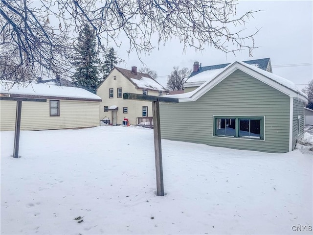 view of snow covered back of property