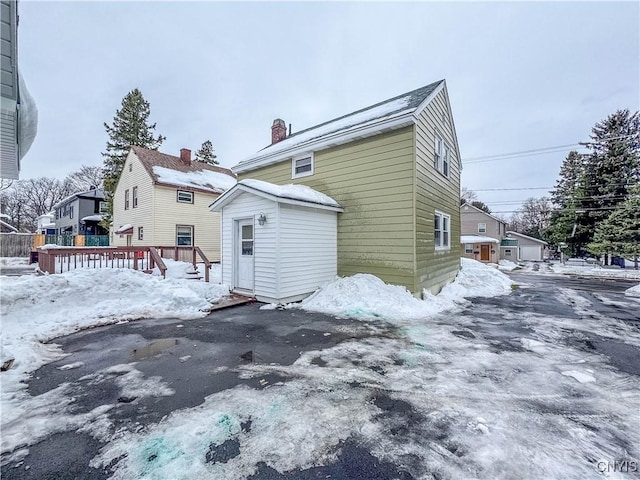 snow covered property with a wooden deck