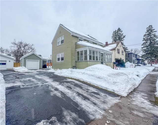 view of front of home with a garage and an outbuilding