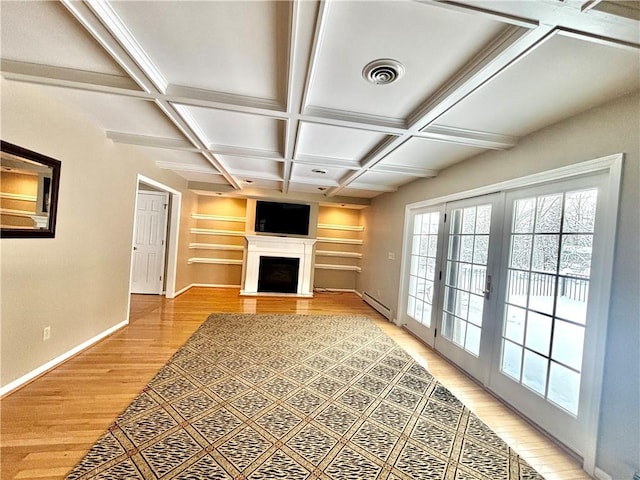 unfurnished living room with coffered ceiling, a fireplace, visible vents, french doors, and light wood-type flooring