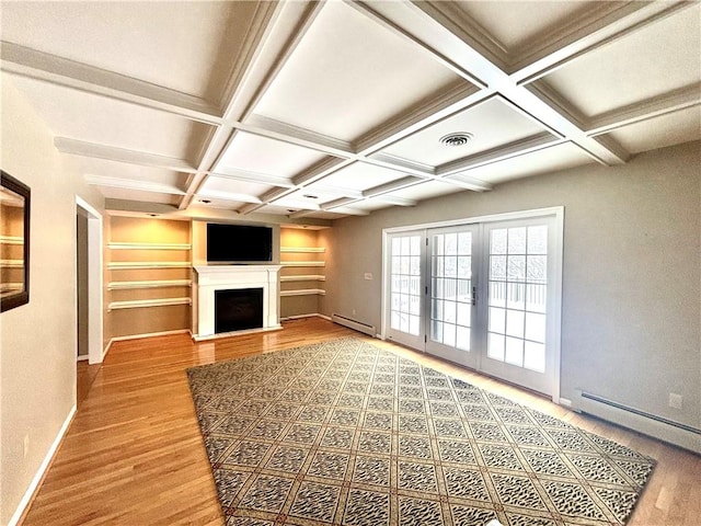 unfurnished living room featuring coffered ceiling, baseboard heating, wood finished floors, and french doors