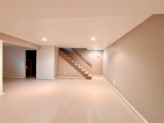 finished basement with visible vents, stairs, baseboards, and recessed lighting