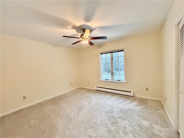 carpeted empty room with baseboard heating, a ceiling fan, and baseboards