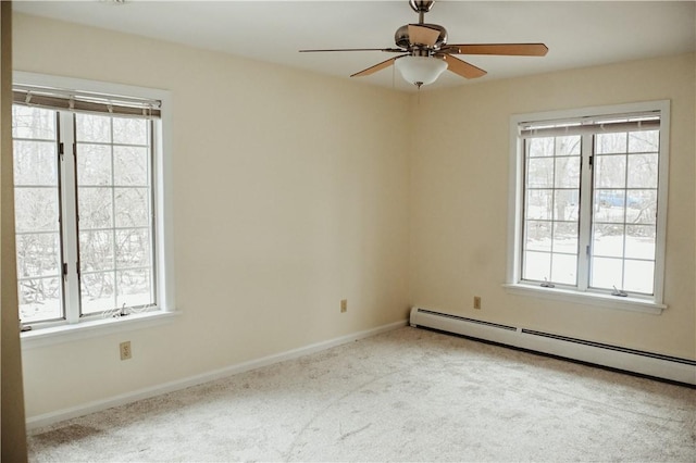 carpeted spare room featuring baseboard heating, a ceiling fan, and baseboards