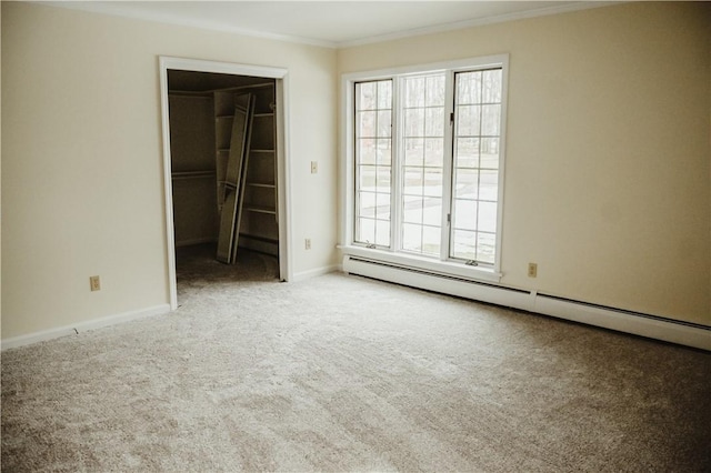 unfurnished bedroom with baseboards, a baseboard radiator, carpet, a spacious closet, and crown molding