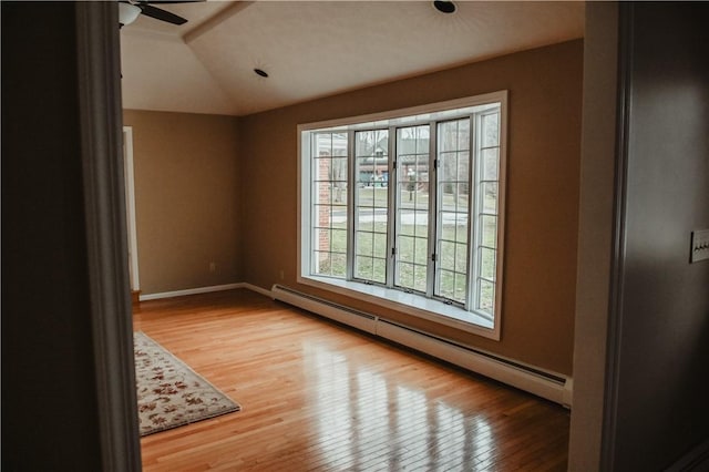 unfurnished room with lofted ceiling, ceiling fan, a baseboard radiator, baseboards, and wood-type flooring