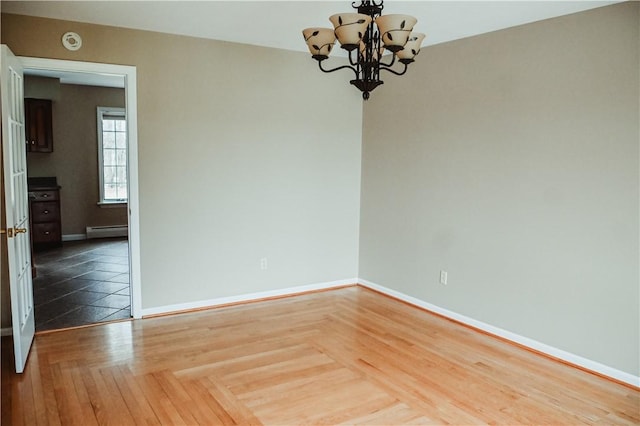 unfurnished room with a baseboard heating unit, parquet flooring, a chandelier, and baseboards