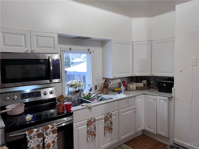 kitchen featuring light stone counters, white cabinetry, sink, and appliances with stainless steel finishes