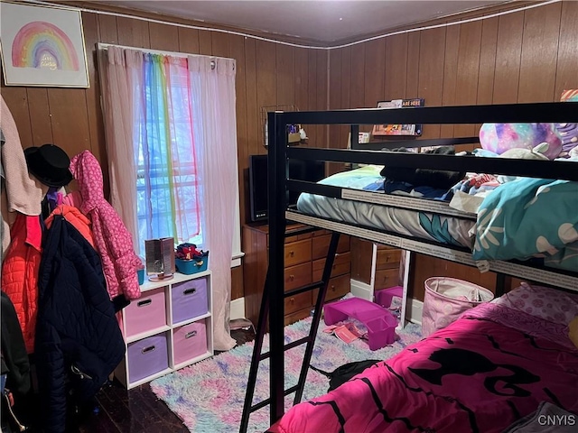 bedroom featuring wood walls