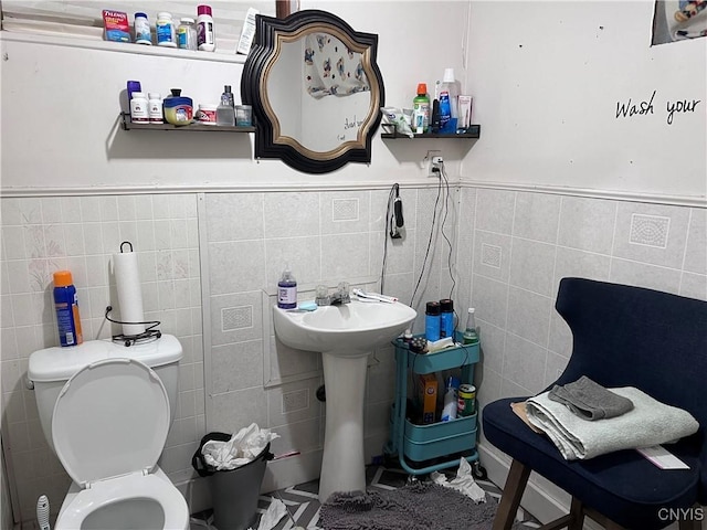 bathroom with toilet and tile walls