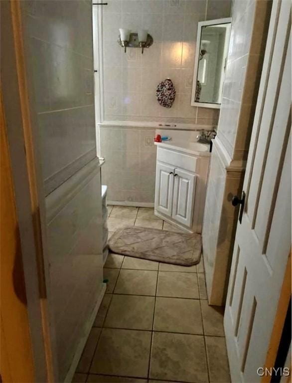 bathroom with tile patterned flooring, vanity, and tile walls