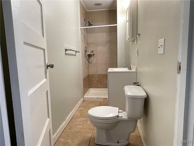 bathroom featuring a tile shower, tile patterned floors, vanity, and toilet