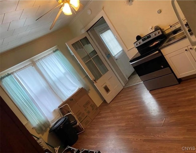 kitchen with white cabinets, stainless steel electric range, ceiling fan, and dark wood-type flooring