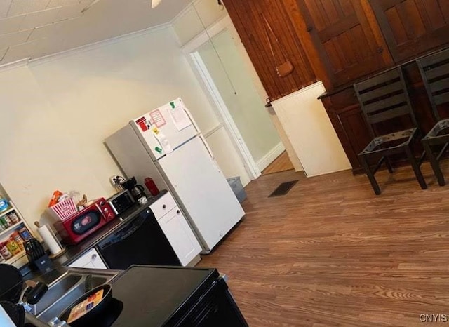 kitchen with white fridge and dark wood-type flooring