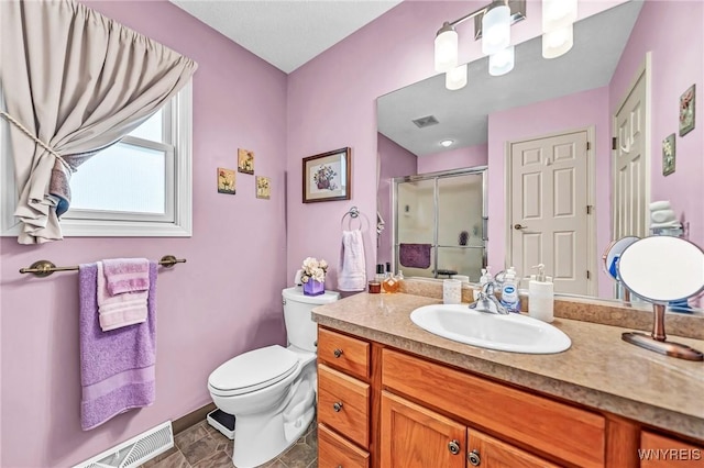 bathroom with vanity, toilet, and a shower with shower door