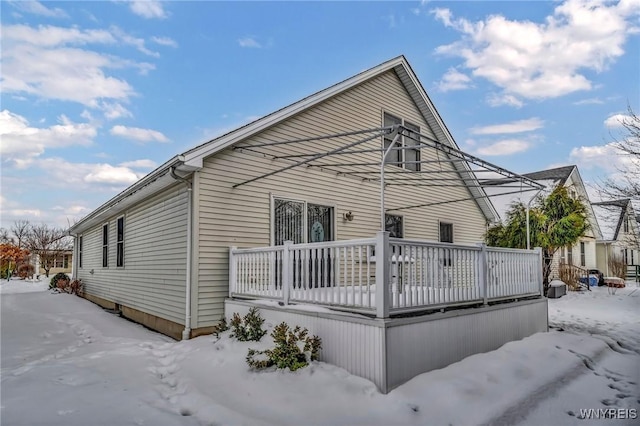 view of snowy exterior featuring a deck