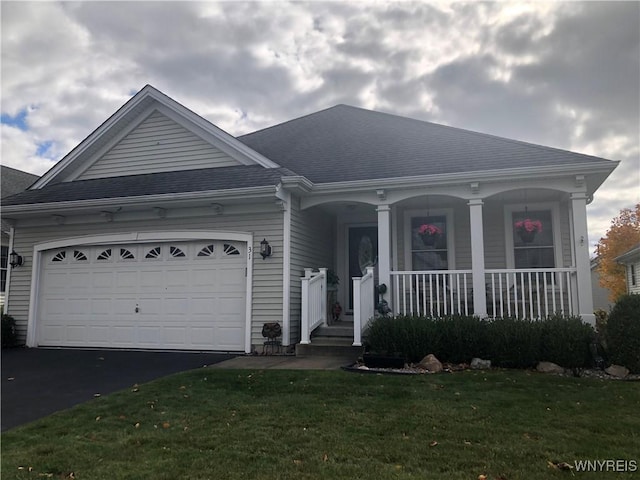 view of front of house featuring a porch, a garage, and a front lawn