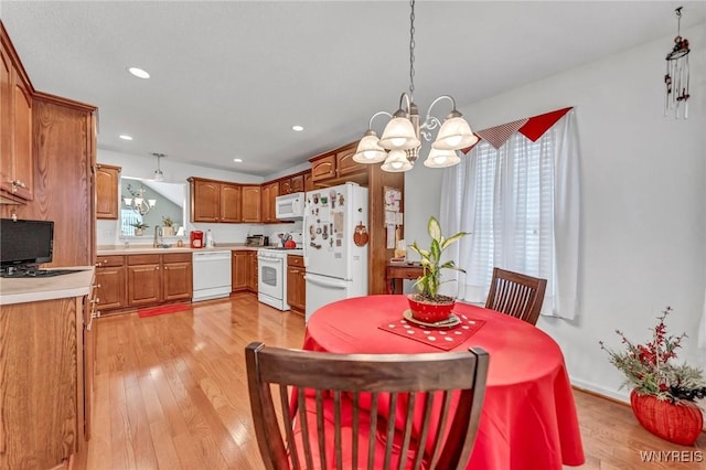 dining room featuring light hardwood / wood-style flooring, a chandelier, and sink