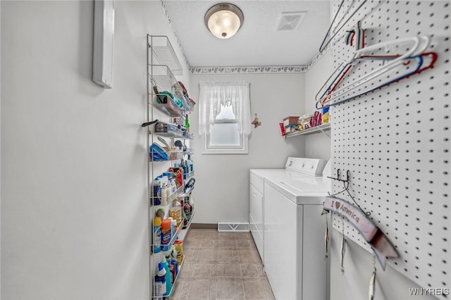 clothes washing area with a textured ceiling and washing machine and dryer