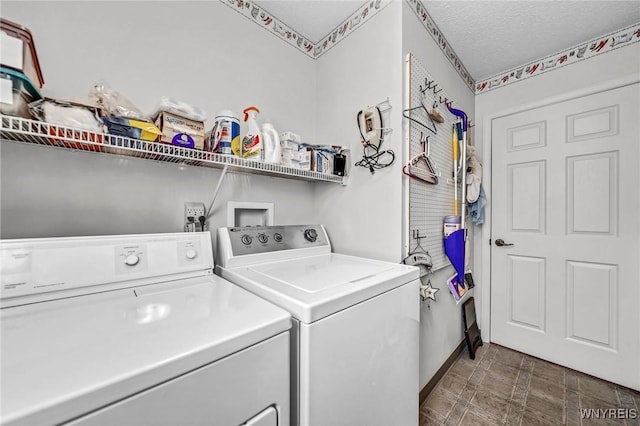 clothes washing area with a textured ceiling and separate washer and dryer