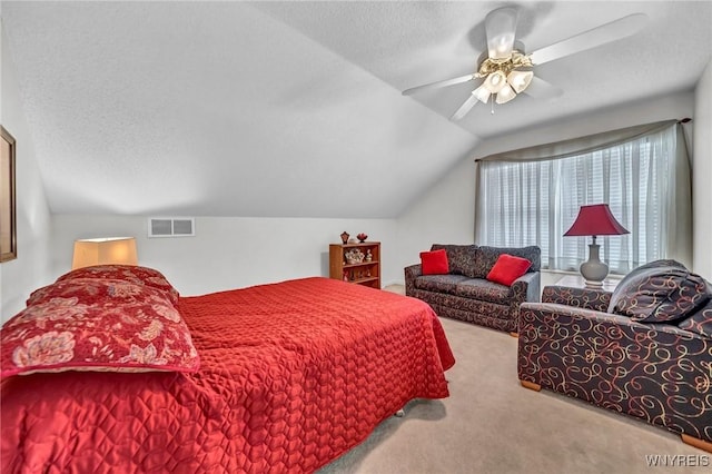 bedroom featuring ceiling fan, light colored carpet, a textured ceiling, and vaulted ceiling