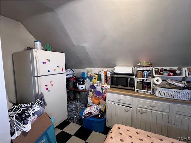 kitchen with white fridge and vaulted ceiling