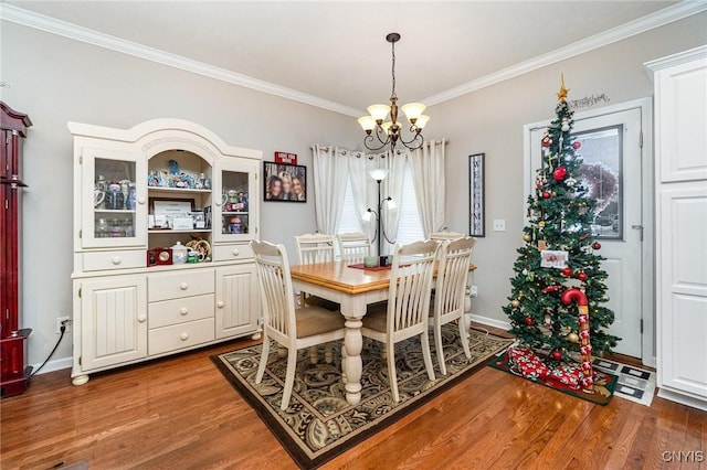 dining room featuring a notable chandelier, dark hardwood / wood-style flooring, and ornamental molding