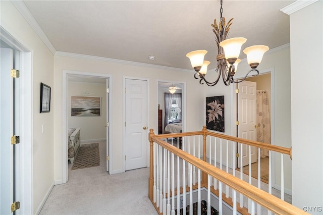 hallway with crown molding, light colored carpet, and an inviting chandelier