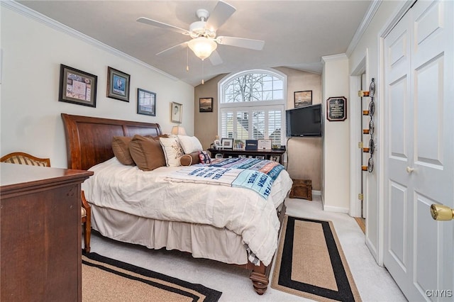 carpeted bedroom with a closet, ceiling fan, and crown molding