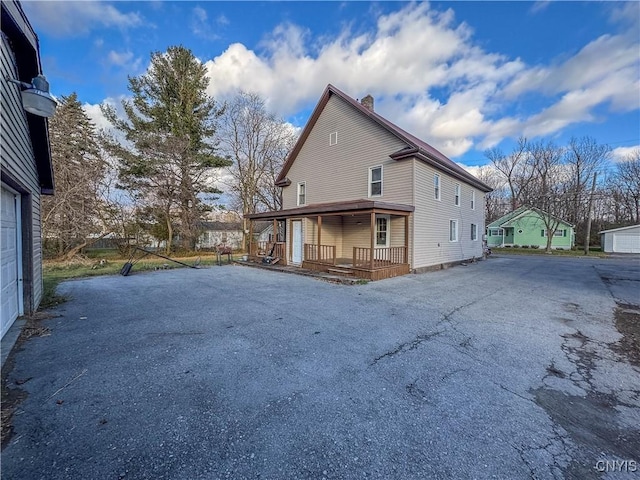 view of side of home with a garage and covered porch