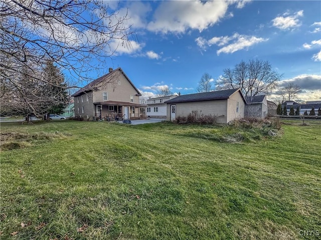 back of property with a yard and a patio area