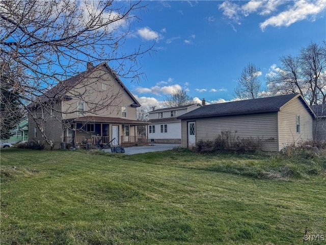 back of property with a yard and a patio