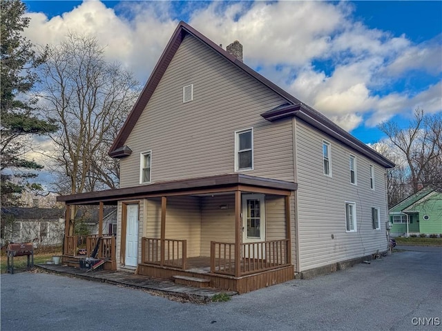 back of house featuring covered porch