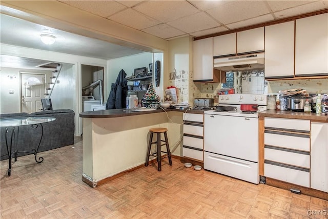 kitchen with white cabinets, white electric range oven, a paneled ceiling, and light parquet flooring