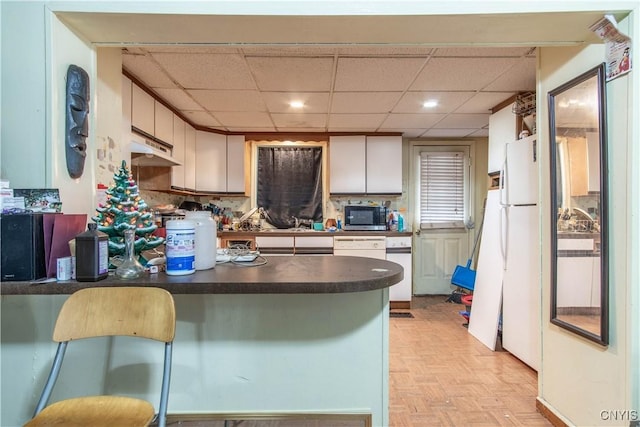 kitchen featuring a kitchen breakfast bar, tasteful backsplash, white fridge, kitchen peninsula, and light parquet flooring