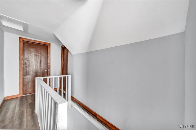 corridor with hardwood / wood-style flooring and vaulted ceiling