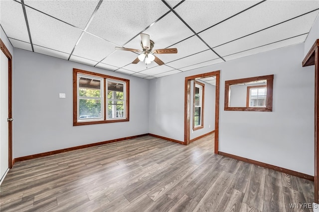 spare room with a paneled ceiling, ceiling fan, and hardwood / wood-style flooring