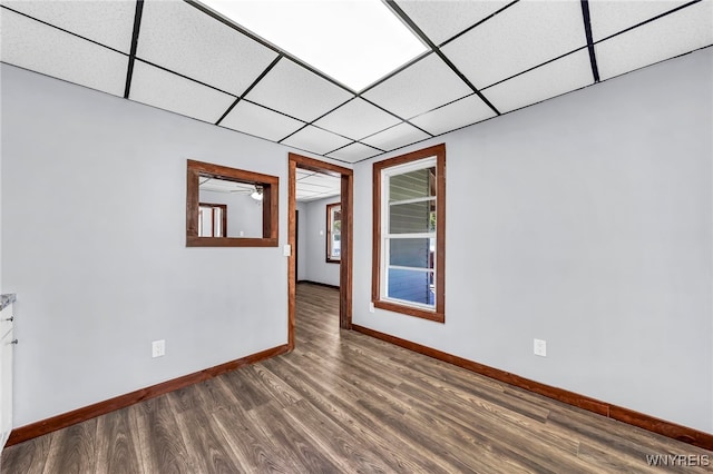 spare room with a paneled ceiling, hardwood / wood-style flooring, and ceiling fan