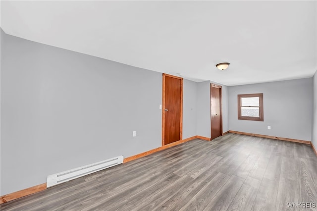 empty room with hardwood / wood-style floors and a baseboard radiator