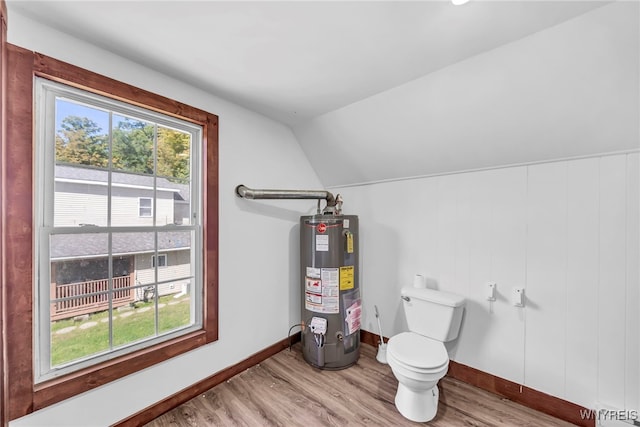 bathroom with lofted ceiling, hardwood / wood-style flooring, gas water heater, and toilet